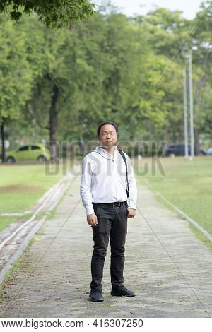 Asian Freelance Long Hair Man Standing And Posting On The Walk Way In The Garden Outdoor Field With 