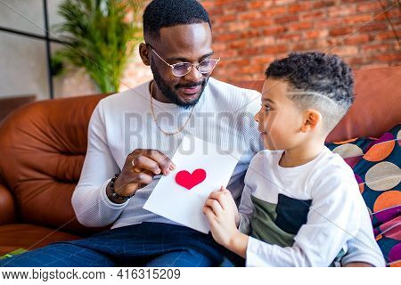 Afro American Baby Giving To Dad A Valentines Day Picture In Living Room