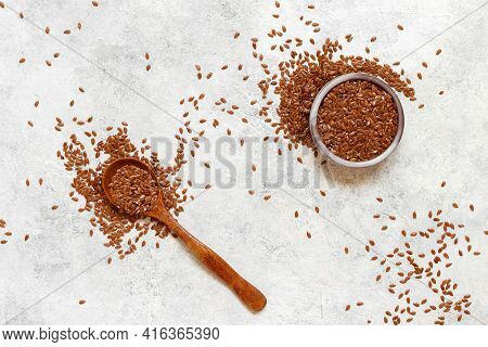 Raw Flax Seeds In A Ceramicbowl With A Wooden Spoon Top View