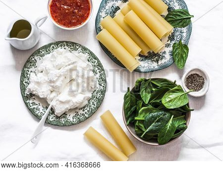Ingredients For Making Cannelloni With Spinach And Ricotta Baked With Tomato Sauce And Mozzarella On