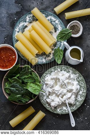 Ingredients For Making Cannelloni With Spinach And Ricotta On A Dark Background, Top View