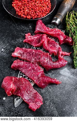Raw Marbled Meat Cut Into Thin Strips For Beefstroganoff. Black Background. Top View