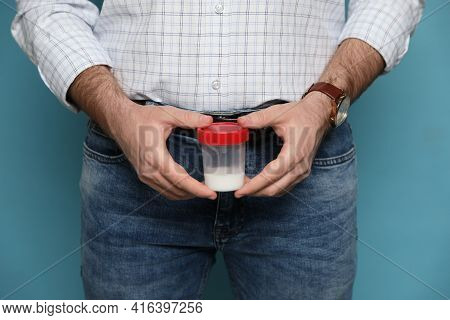 Donor Holding Container With Sperm On Turquoise Background, Closeup