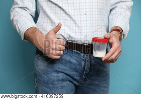Donor Holding Container With Sperm On Turquoise Background, Closeup