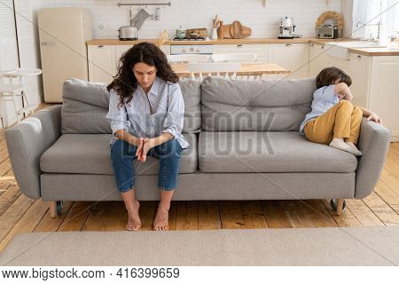 Pensive Young Mommy Sit On Couch With Son Offended With Family Fight And Moms Scolding. Disobedient 