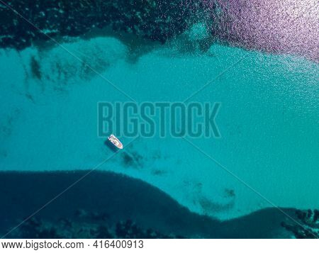 Aerial View Of A Rigid Inflatable Boat Moored In A Translucent Turquoise Channel In The Mediterranea