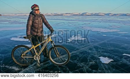 Man Is Riding Bicycle On The Ice. Ice Of Frozen Lake Baikal. Rid