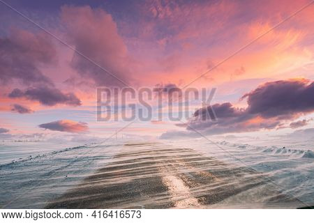 Snow-covered Open Slippy Road During A Snowstorm Blizzard In Winter. Altered Colorful Sunset Sunrise
