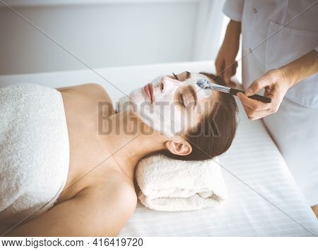 Beautiful Brunette Woman Enjoying Applying Cosmetic Mask With Closed Eyes Comfortable And Blissful. 