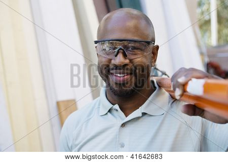 En African American arbejder iført beskyttelsesbriller på byggepladsen