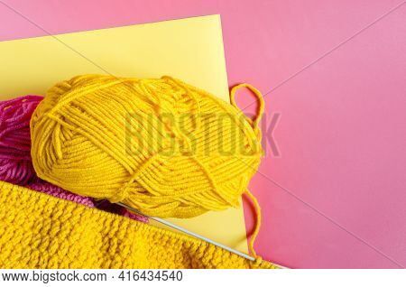 Skein Of Bright Yellow Yarn On With Knitting Needles On A Colored Background Needlework On The Backg