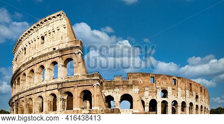 Rome, Italy. Arches Archictecture Of Colosseum (colosseo) Exterior With Blue Sky Background And Clou