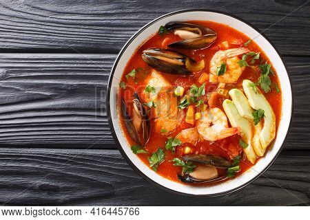 Delicious Soup With Seafood, Corn, Celery, Tomatoes, Carrots And Avocado Close-up In A Bowl On The T