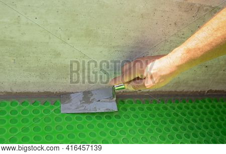 Worker Applies Waterproofing With A Small Brush