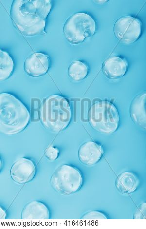 Drops Of Gel With Hyaluronic Acid In The Form Of A Smear Of Glossy Texture On A Blue Background.