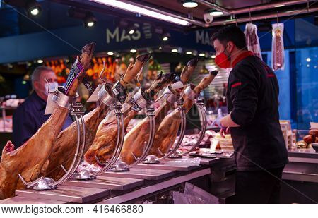 Spain, Barcelona, January, 2021 - Spanish Dealer Sells Iberico And Serrano Jamon, Standing On Metal 