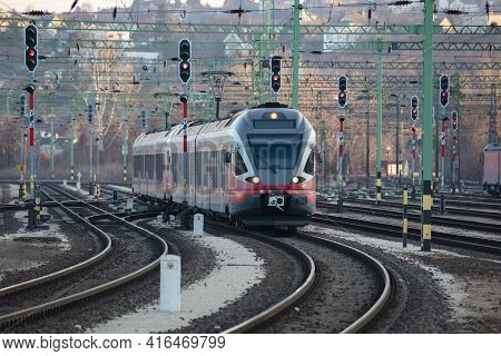 Untitled Red Passenger Train Arrival At Railway Train Station. Platform Track Front View. Public Tra