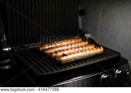 Grilled Meat Sausages For Hot Dog, Kupaty, Fatty Food Cooked On The Barbecue, With Fresh Vegetables 