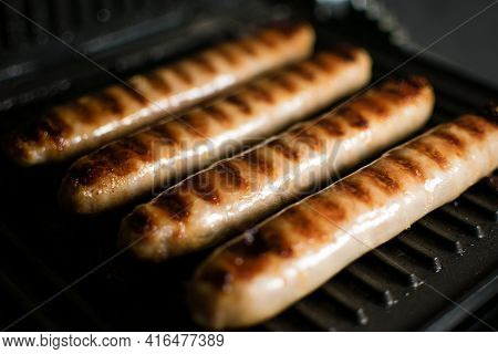 Grilled Meat Sausages For Hot Dog, Kupaty, Fatty Food Cooked On The Barbecue, With Fresh Vegetables 