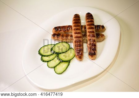 Grilled Meat Sausages For Hot Dog, Kupaty, Fatty Food Cooked On The Barbecue, With Fresh Vegetables 