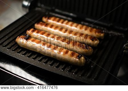 Grilled Meat Sausages For Hot Dog, Kupaty, Fatty Food Cooked On The Barbecue, With Fresh Vegetables 