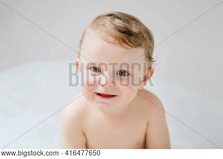Cute Adorable Baby Child Taking Bath In Bathtub At Home. Happy Healthy Boy Or Girl Playing, Splashin