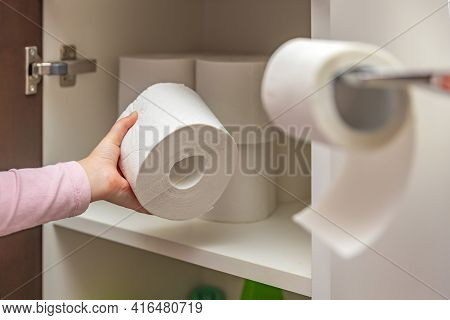 Toilet Paper, Roll Of Toilet Paper In Hand. Stocks Of Toilet Paper. Girl Puts Toilet Paper In The Ca