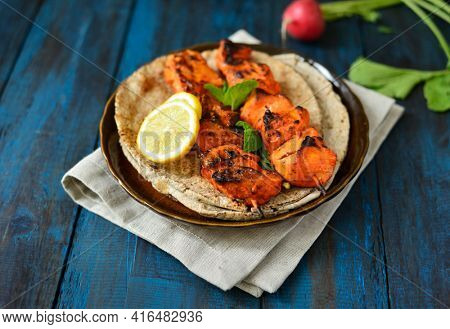Very juicy and tender grilled chicken tikka or kabab served on a platter with flat bread. Chicken tikka is a most popular non vegetarian dish in India, Asia and Middle Eastern countries.
