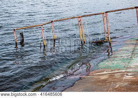 Old Rusty Sunken Pier In The Water On The Territory Of The River Port. Old Sunken Rusty Structure On