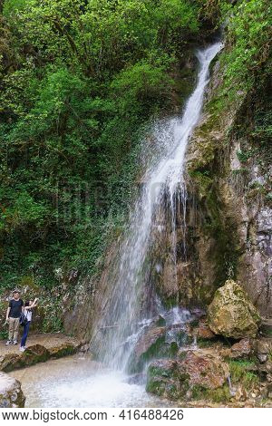 Abkhazia, May 02, 2019-clear Water Flows From A Height-tourists Take Pictures Of The Beautiful Water
