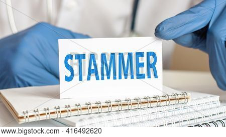 Doctor Holding A White Paper Card With Text: Stammer. Healthcare Conceptual For Hospital, Clinic And