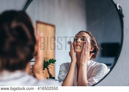 Woman Applies Foam To Her Face, Cleansing Her Skin.