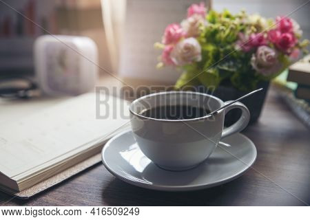 Coffee Break Time. A Cup Of Coffee, Diary, Clock, Calendar, And Rose Flower Vase Place On Home Offic
