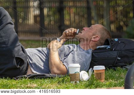 Frederick, Maryland, Usa 04-07-2021: A Young Homeless Man Wearing Hospital Bracelet Is Basking On Th
