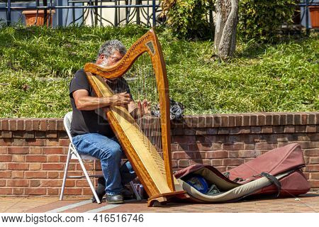 Frederick, Md, Usa 04-07-2021:  Closeup Image Of A Street Musician Performing On The Sidewalk By Pla