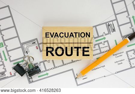 Construction Drawings And Wooden Bars With Text Evacuation Route And Paper Clips. Architecture And B
