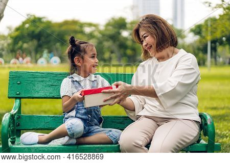 Portrait Of Happy Asian Grandmother And Little Asian Cute Girl Enjoy Relax In Summer Park.young Girl