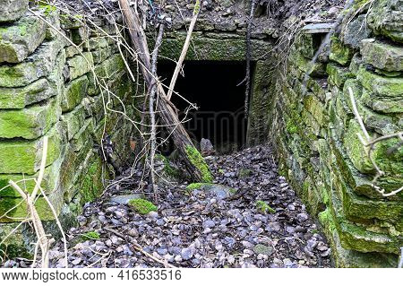 Old Dark Entrace With Stone Walls With Moss