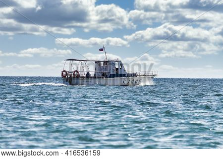 White Fast Boat Sails By Sea. Sunny Autumn Day. Side View. Crimea, Sudak - 10 October 2020.