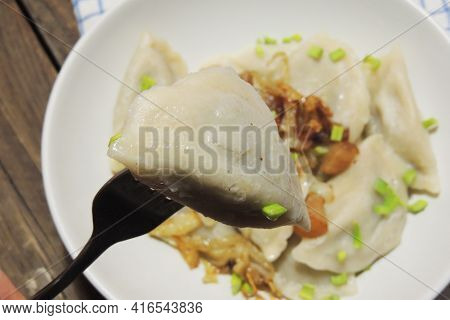 Fried Dumplings Stuffed With Cabbage And Meat Sprinkled With Bacon Greaves And Chopped Parsley On A