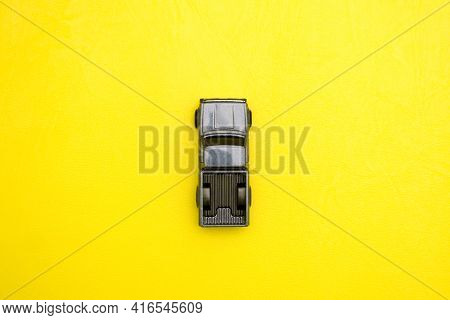 A Close-up Of A Toy Car On A Yellow Background. Lonely Car Made Of Metal View From Above