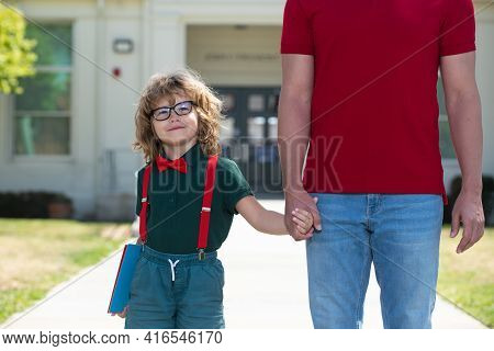 Portrait Of Happy Nerd Pupil Holding Teachers Hand. School, Family, Education And Outdoor Concept