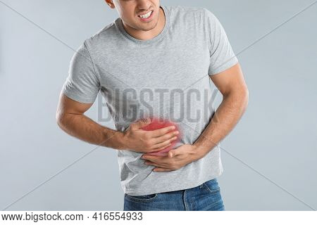 Man Suffering From Liver Pain On Grey Background, Closeup