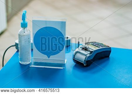 Hand Sanitized And Payment Terminal Stands On Blue Table. Banking. Copy-paste Empty Sign. Disinfecti