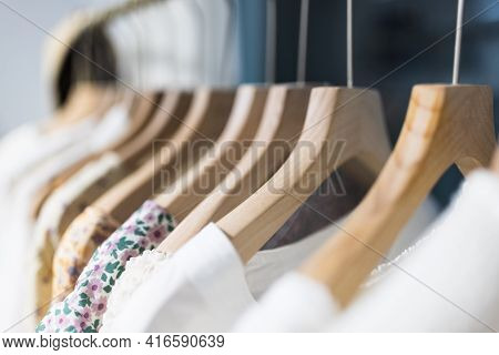 Row Of Different Female Clothes Hanging On Rack In Hipster Fashion Show Room In Shopping Mall. Trend