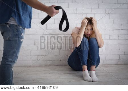 Life Threatening, Tyranny And Domestic Violence. Frightened Young Female Covers Her Head With Hands