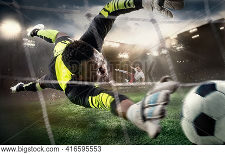 African Male Soccer Or Football Player, Goalkeeper In Action At Stadium. Young Man Catching Ball, Tr