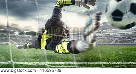 African Male Soccer Or Football Player, Goalkeeper In Action At Stadium. Young Man Catching Ball, Tr