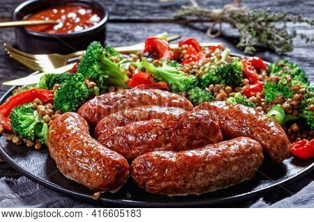 Italian Cotechino Pork Sausages Braised With Brown Lentils, Red Pepper, And Broccoli Served On A Bla