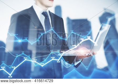 Businessman Holding A Laptop And Watching On The Holo Tading Charts, Background With City View, Mark
